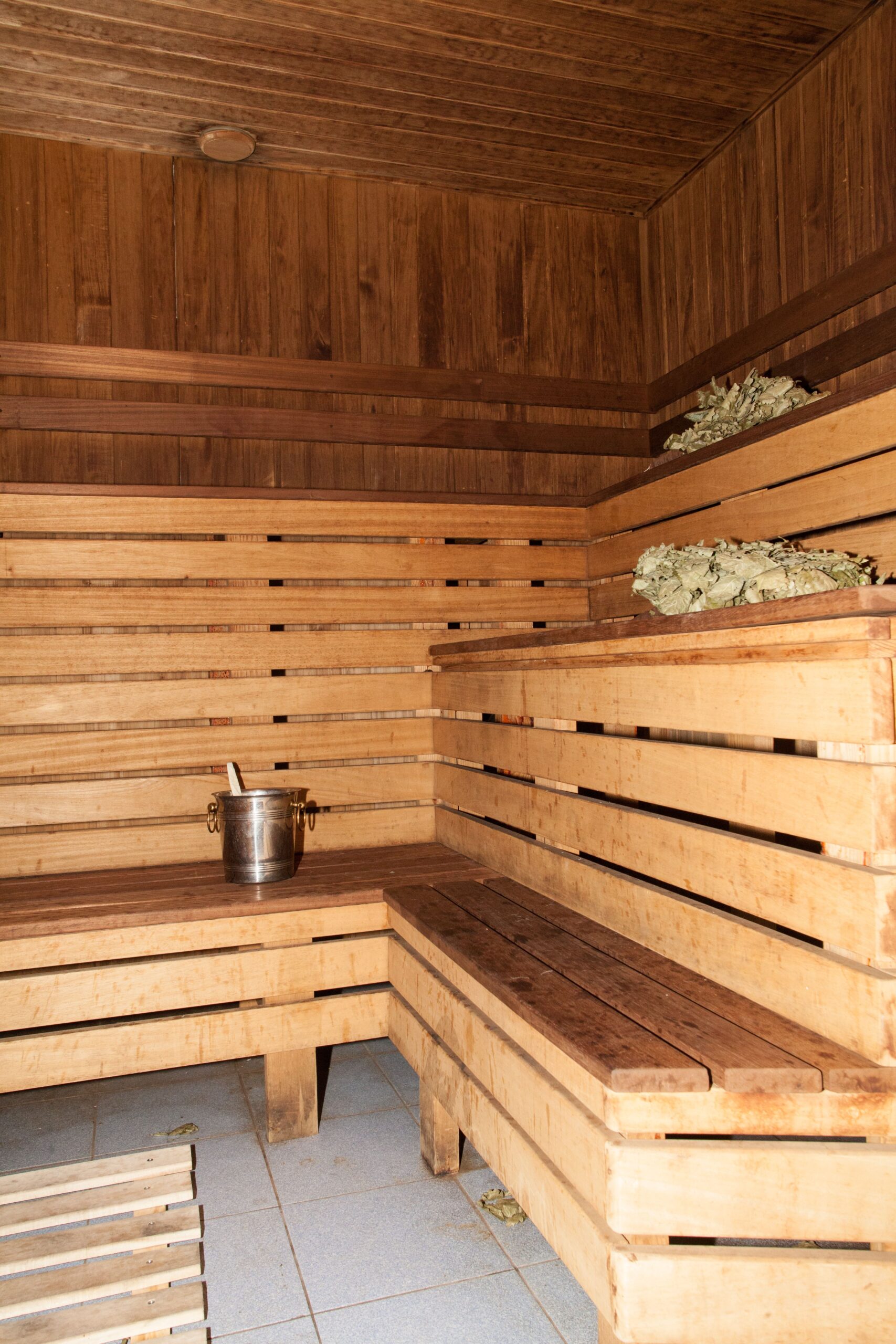 Interior de sauna em madeira com bancos e equipamentos